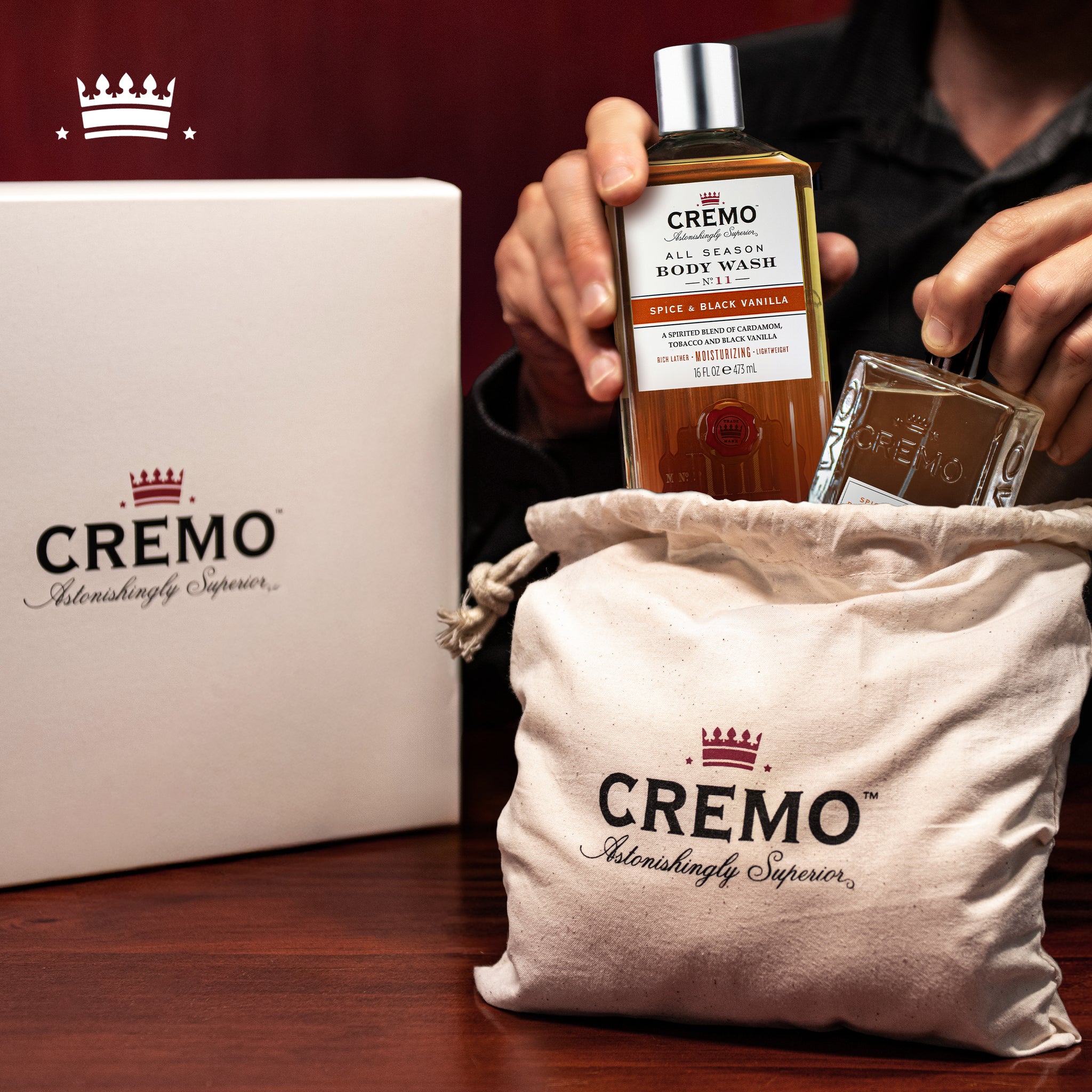 Cremo Spice & Black Vanilla Eau De Toilette and Body Wash Gift Set placed inside a branded Cremo gift set dust bag, with the gift set box displayed behind it.