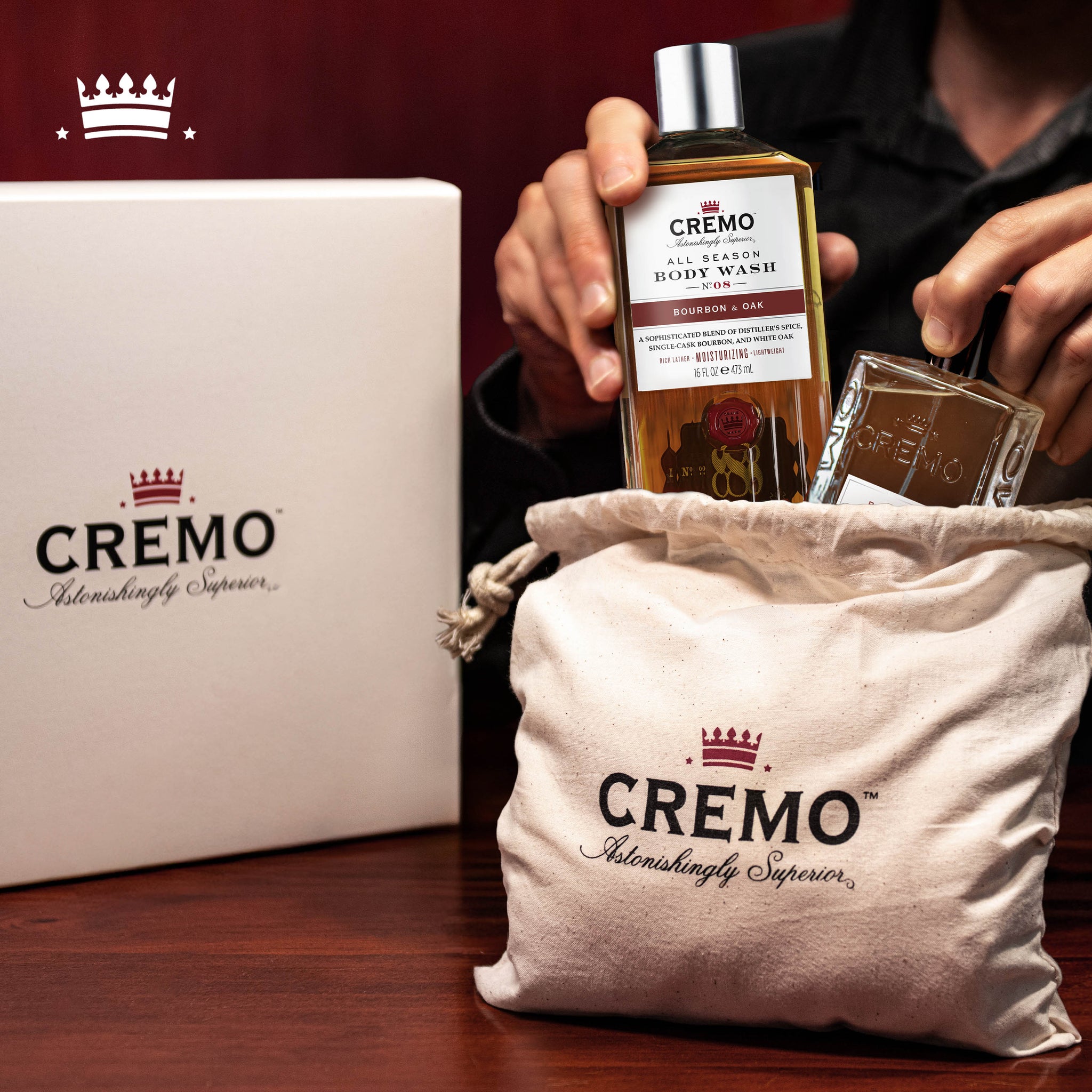 Cremo Bourbon & Oak Eau de Toilette and Body Wash Gift Set placed inside a branded Cremo gift set dust bag, with the gift set box displayed behind it.