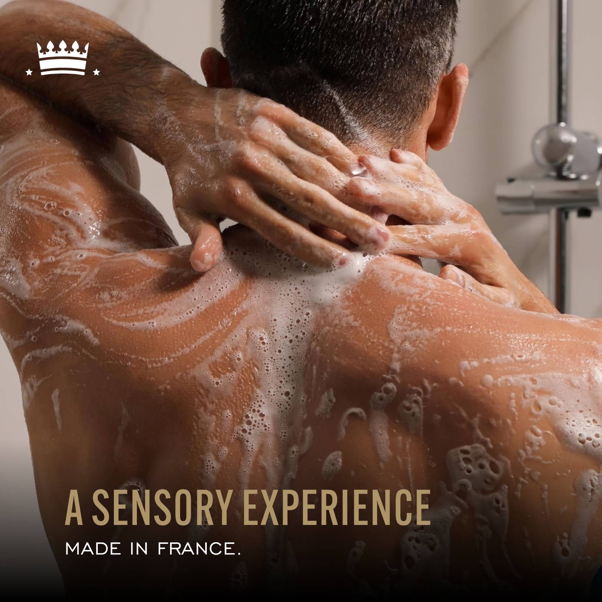Back view of a model applying body wash to their back, with text reading “A sensory experience made in France.”
